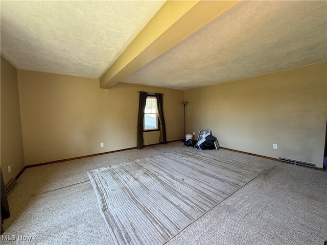 empty room with a textured ceiling and carpet floors