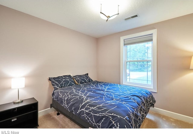 carpeted bedroom featuring a textured ceiling