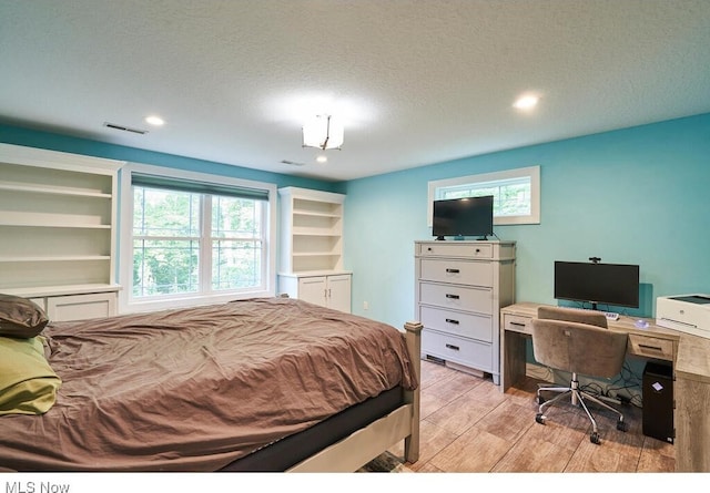 bedroom featuring a textured ceiling and light wood-type flooring