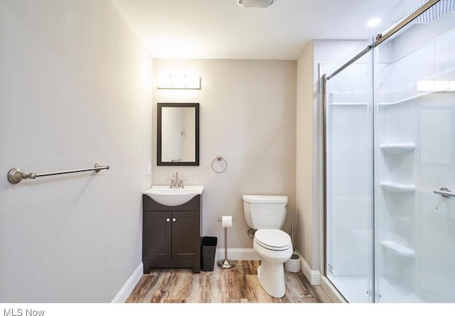 bathroom with vanity, toilet, hardwood / wood-style flooring, and an enclosed shower