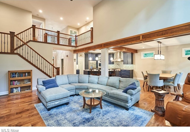 living room featuring a towering ceiling and hardwood / wood-style flooring