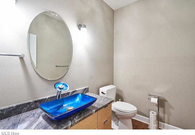 bathroom featuring vanity, toilet, and wood-type flooring