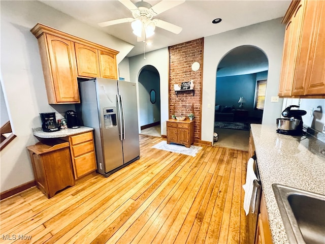 kitchen with light wood-type flooring, ceiling fan, dishwashing machine, sink, and stainless steel fridge with ice dispenser