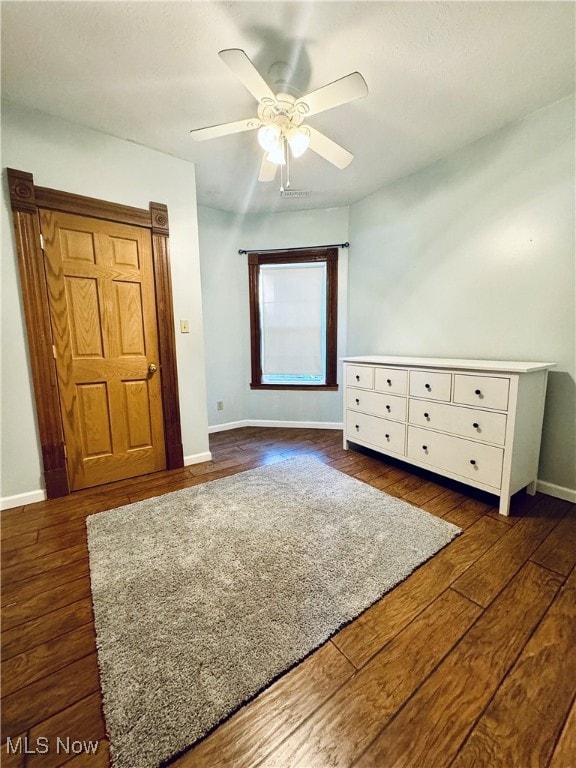 unfurnished bedroom featuring ceiling fan and dark hardwood / wood-style floors