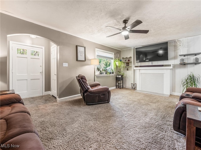 living room featuring carpet flooring, ceiling fan, and a textured ceiling