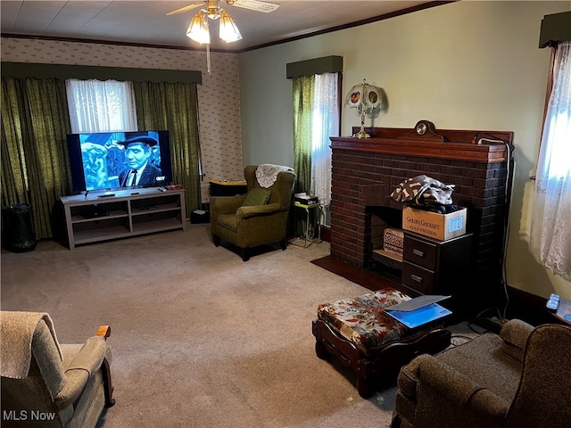 carpeted living room featuring a brick fireplace, a wealth of natural light, ceiling fan, and ornamental molding