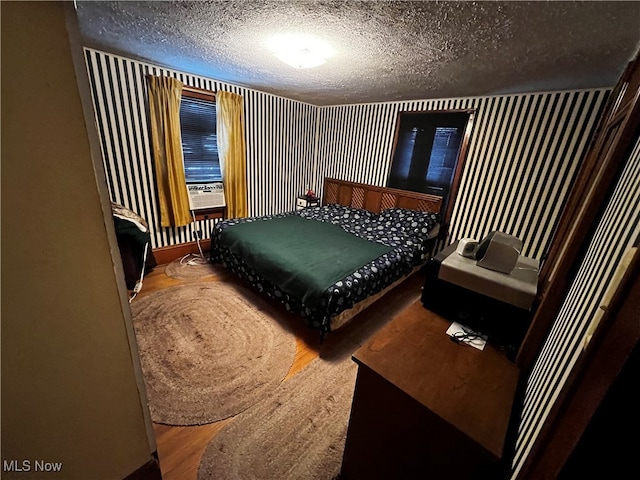 bedroom with a textured ceiling and hardwood / wood-style flooring