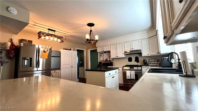 kitchen with white cabinets, stainless steel appliances, a chandelier, sink, and pendant lighting