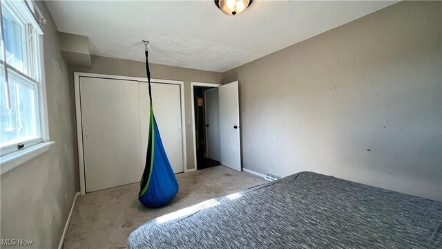 unfurnished bedroom with a closet and light carpet