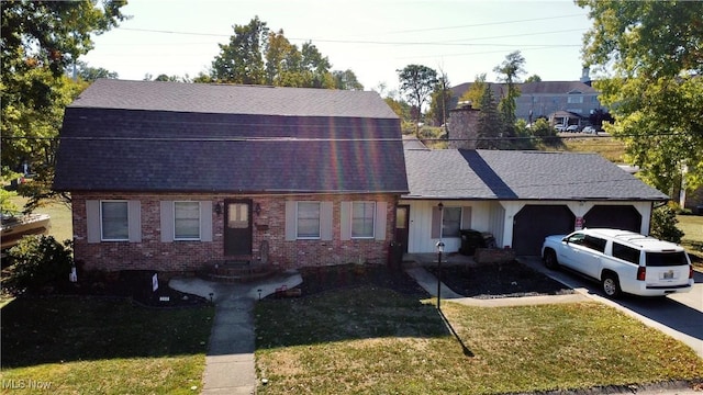 view of front of house with brick siding, an attached garage, a front yard, and roof with shingles