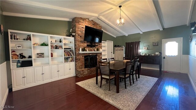 dining area featuring a fireplace, dark hardwood / wood-style floors, and lofted ceiling with beams