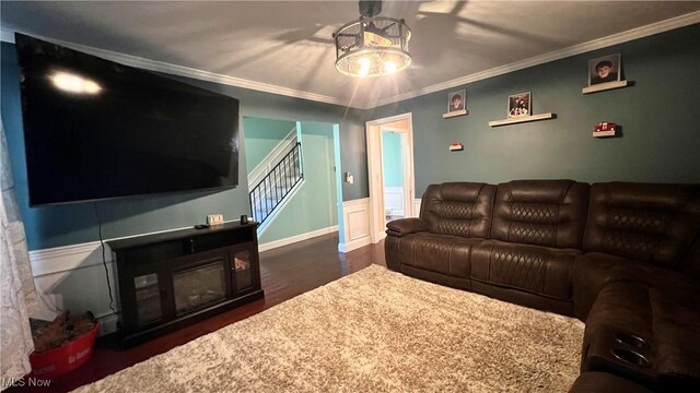 living room featuring crown molding, dark wood-type flooring, and an inviting chandelier