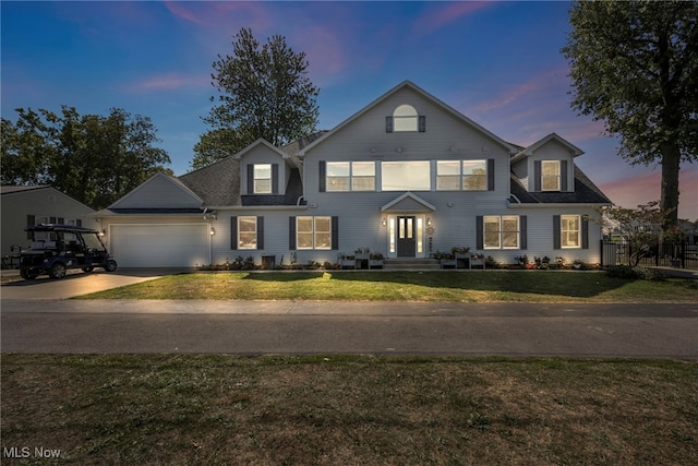 view of front of property featuring a garage and a lawn