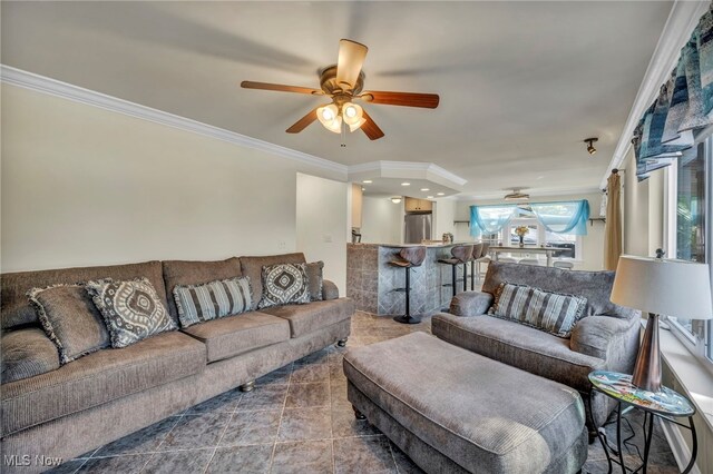 tiled living room with ceiling fan and ornamental molding