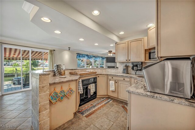 kitchen with light stone counters, kitchen peninsula, black oven, crown molding, and ceiling fan