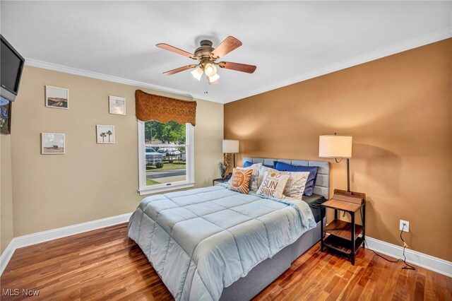 bedroom featuring ceiling fan, hardwood / wood-style floors, and crown molding