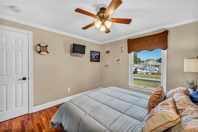 bedroom featuring ceiling fan, hardwood / wood-style flooring, and crown molding