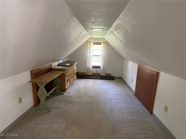 bonus room featuring lofted ceiling and light colored carpet