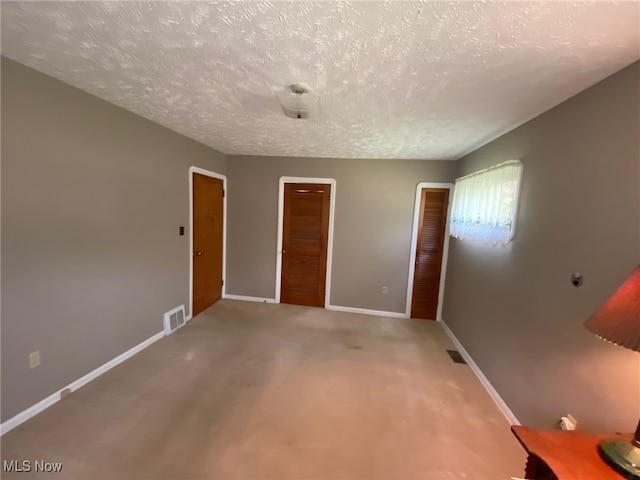 unfurnished room with a textured ceiling and carpet