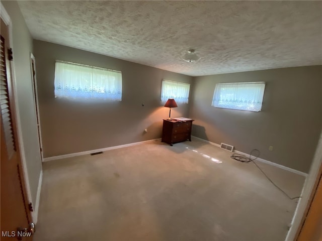 spare room featuring carpet and a textured ceiling