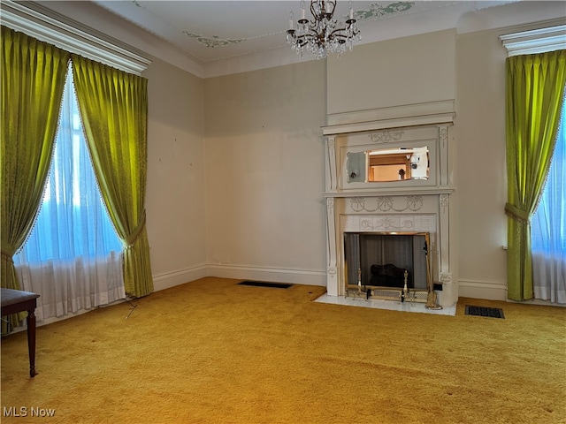 unfurnished living room featuring light carpet, a notable chandelier, and a healthy amount of sunlight