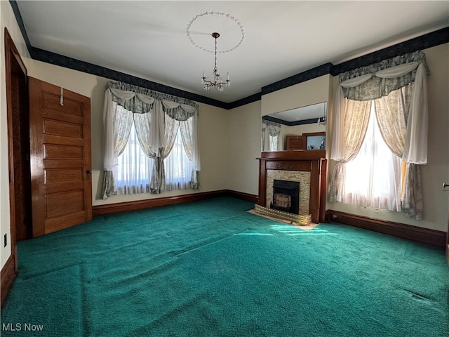 unfurnished living room with crown molding, carpet flooring, and a notable chandelier