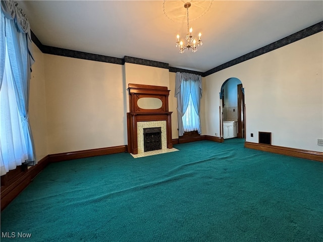 unfurnished living room with a chandelier and carpet