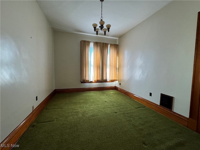 empty room featuring a chandelier and carpet floors