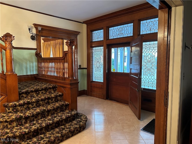 entrance foyer featuring light tile patterned flooring and ornamental molding