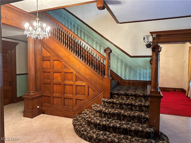 stairway featuring ornamental molding and a chandelier