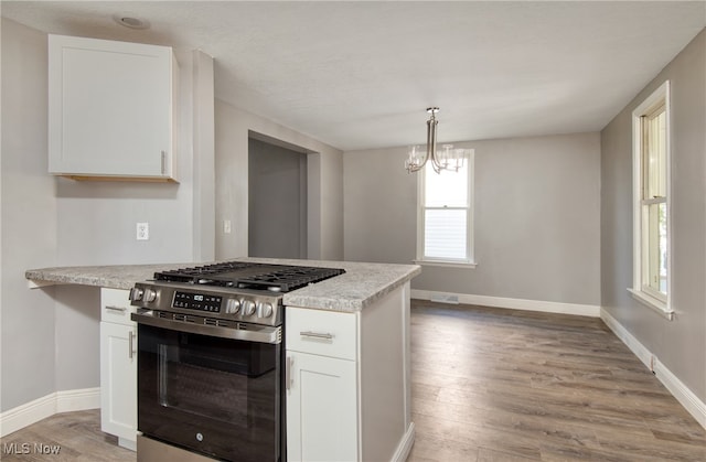 kitchen with white cabinets, gas stove, and light hardwood / wood-style floors