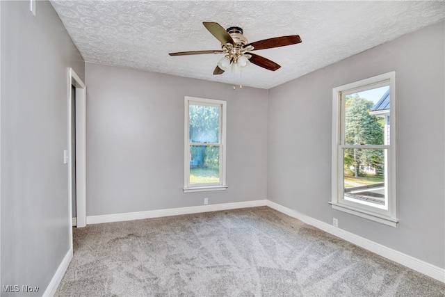 carpeted spare room with ceiling fan and a textured ceiling