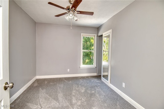 unfurnished room featuring ceiling fan, carpet, and a textured ceiling