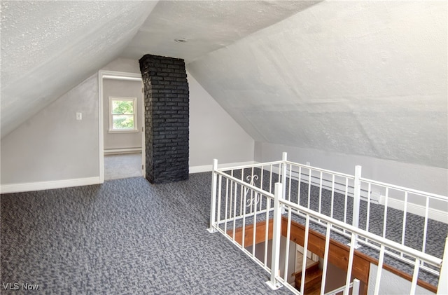 bonus room featuring lofted ceiling, carpet flooring, a baseboard heating unit, and a textured ceiling