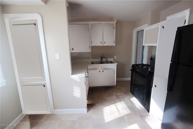 kitchen featuring black appliances, white cabinetry, and sink