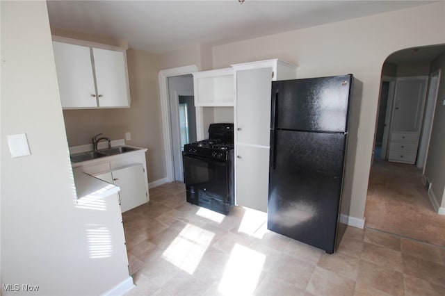 kitchen with white cabinets, black appliances, and sink