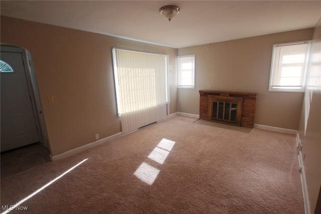 unfurnished living room with a healthy amount of sunlight and light carpet