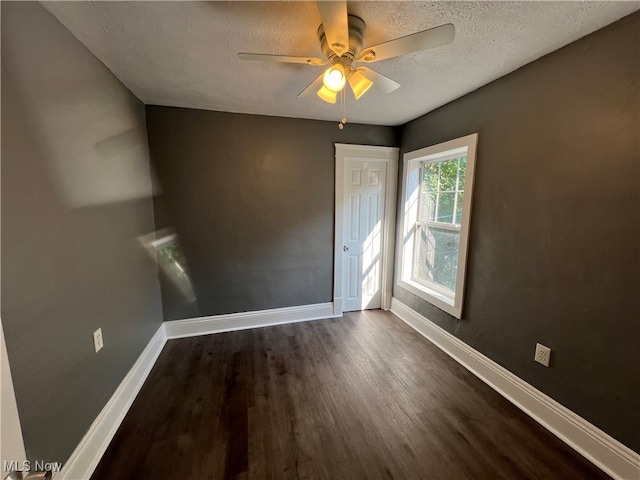 unfurnished room featuring a textured ceiling, ceiling fan, and dark hardwood / wood-style floors