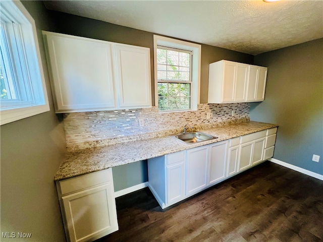 kitchen featuring backsplash, white cabinetry, sink, dark wood-type flooring, and a textured ceiling