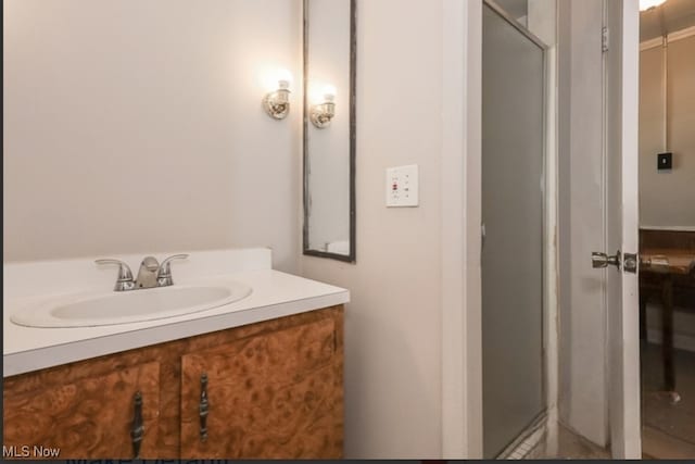 bathroom featuring vanity and a shower with shower door