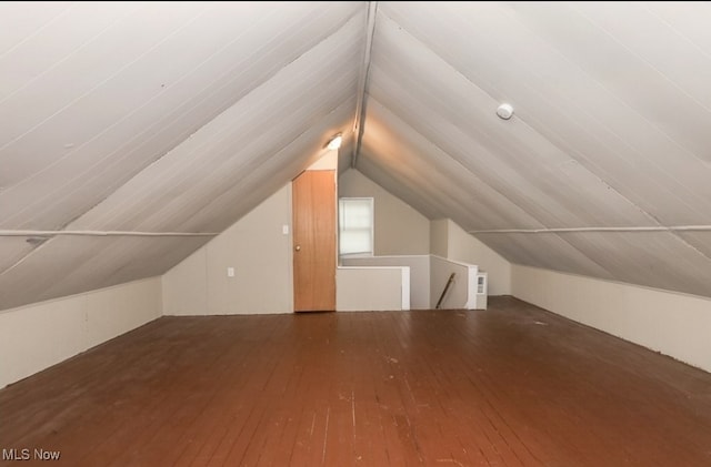 additional living space featuring dark hardwood / wood-style flooring and vaulted ceiling