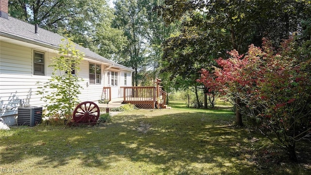 view of yard with a wooden deck and central air condition unit