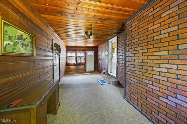 interior space featuring brick wall, wood walls, carpet floors, and wooden ceiling