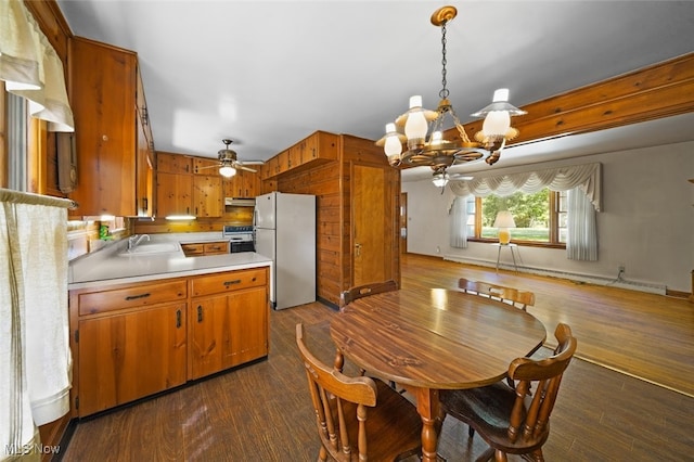 dining room with ceiling fan with notable chandelier, dark hardwood / wood-style flooring, and sink