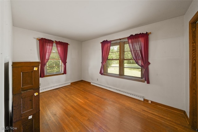 unfurnished room with a baseboard radiator and wood-type flooring