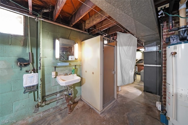 basement featuring sink, heating unit, and water heater