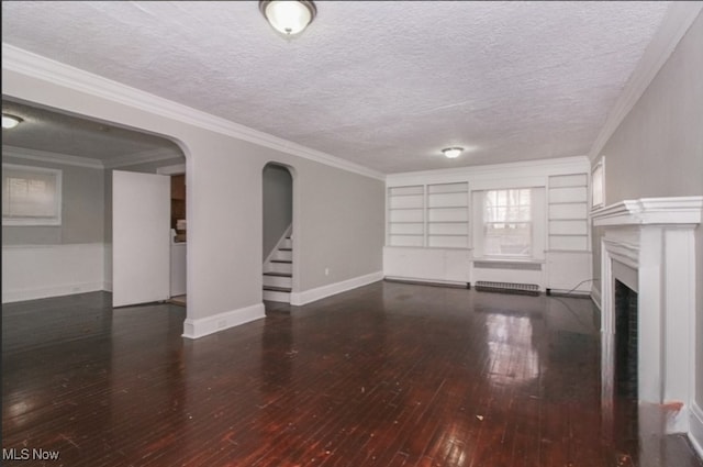 unfurnished living room featuring a textured ceiling, built in features, dark hardwood / wood-style flooring, and crown molding