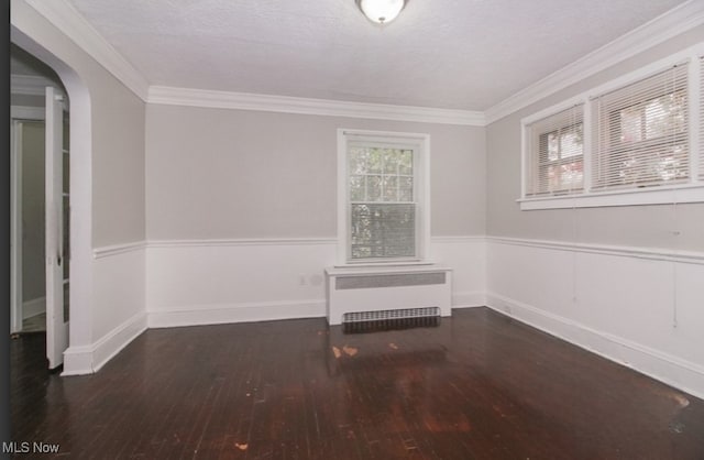 unfurnished room featuring a textured ceiling, ornamental molding, radiator, and dark hardwood / wood-style floors