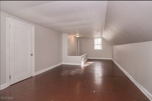 additional living space with lofted ceiling and dark hardwood / wood-style floors