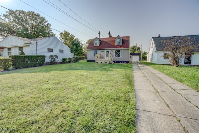 rear view of property featuring a lawn, a garage, and an outdoor structure